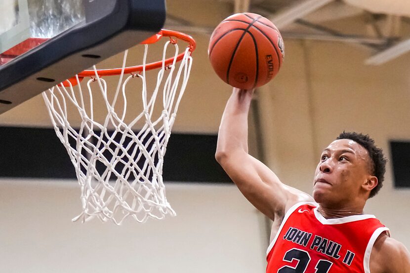 John Paul II's Gabe Warren goes up for a dunk during a high school basketball game against...