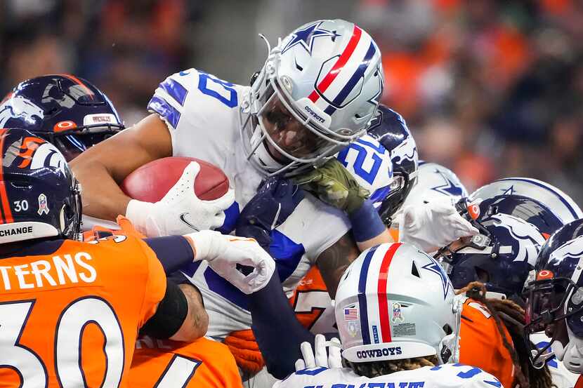 Dallas Cowboys running back Tony Pollard (20) is rapped up by the Denver Broncos return...