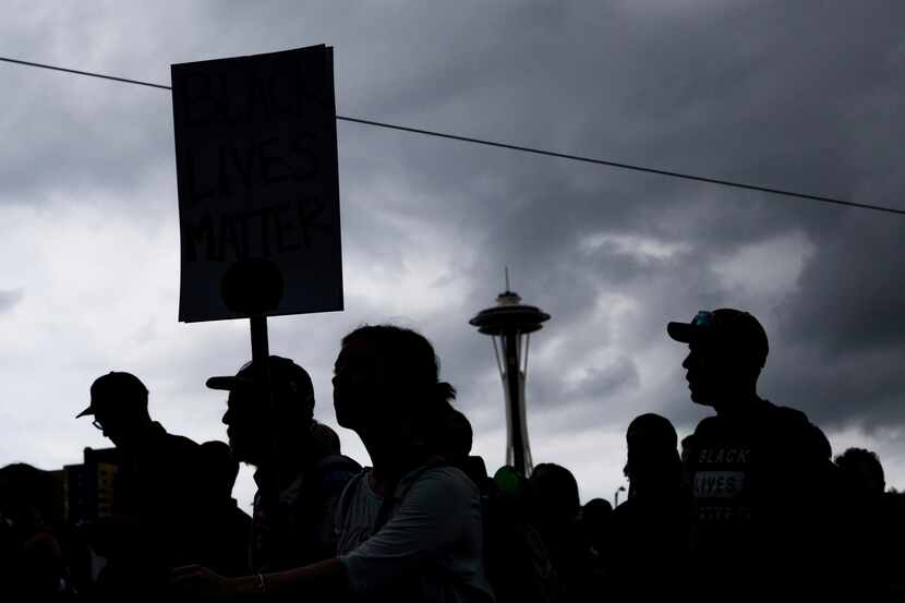 People attend a rally Sunday, Aug. 13, 2017, in Seattle. Hundreds of demonstrators and...