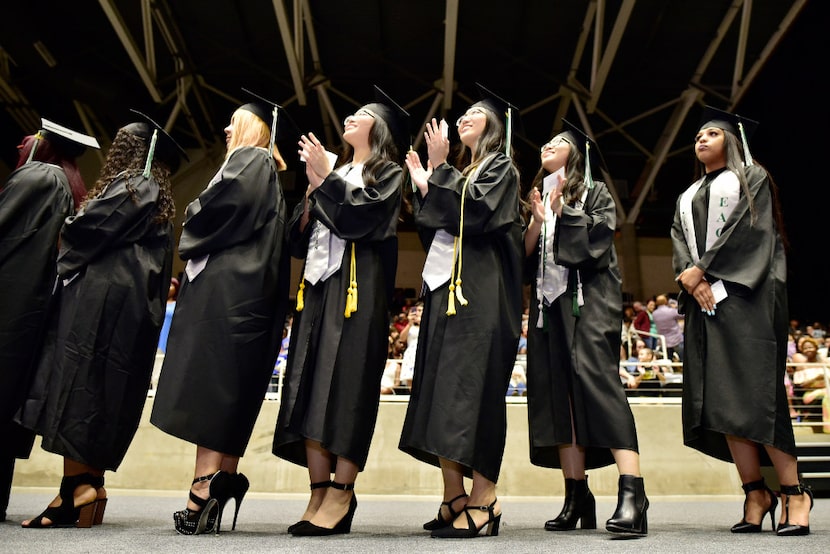 From left, Tran Bao Tran, Han Bao Tran and Ngan Bao Tran wait to receive their diplomas.