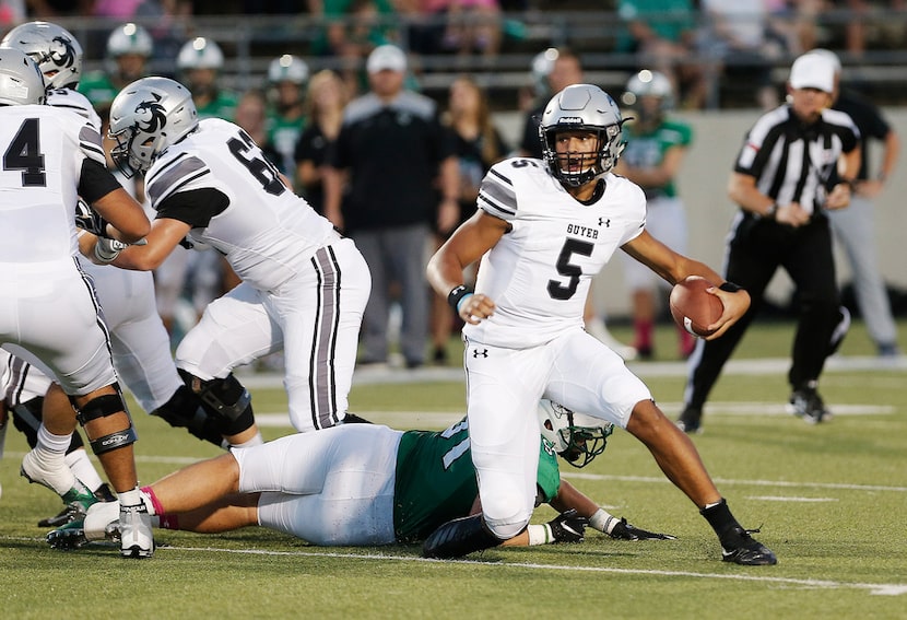 Denton Guyer sophomore quarterback Eli Stowers (5) evades a sack from Southlake Carroll...