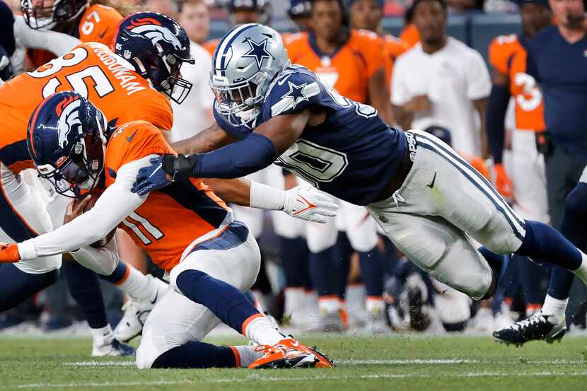 Dallas Cowboys linebacker Devin Harper (50) tackles Denver Broncos quarterback Josh Johnson...
