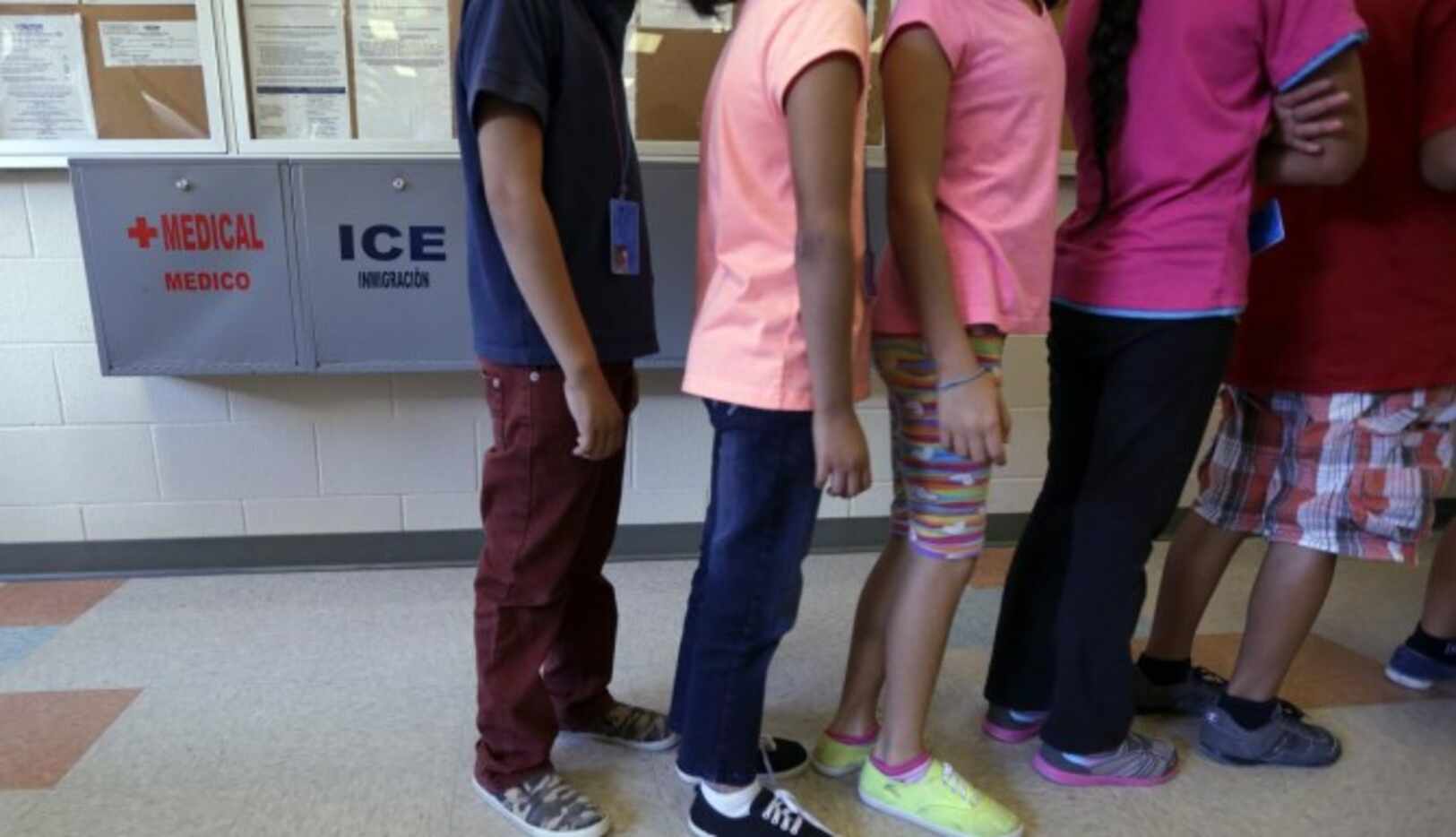 Niños hacen fila en la cafetería de Centro Residencial del Condado Karnes, un centro de...