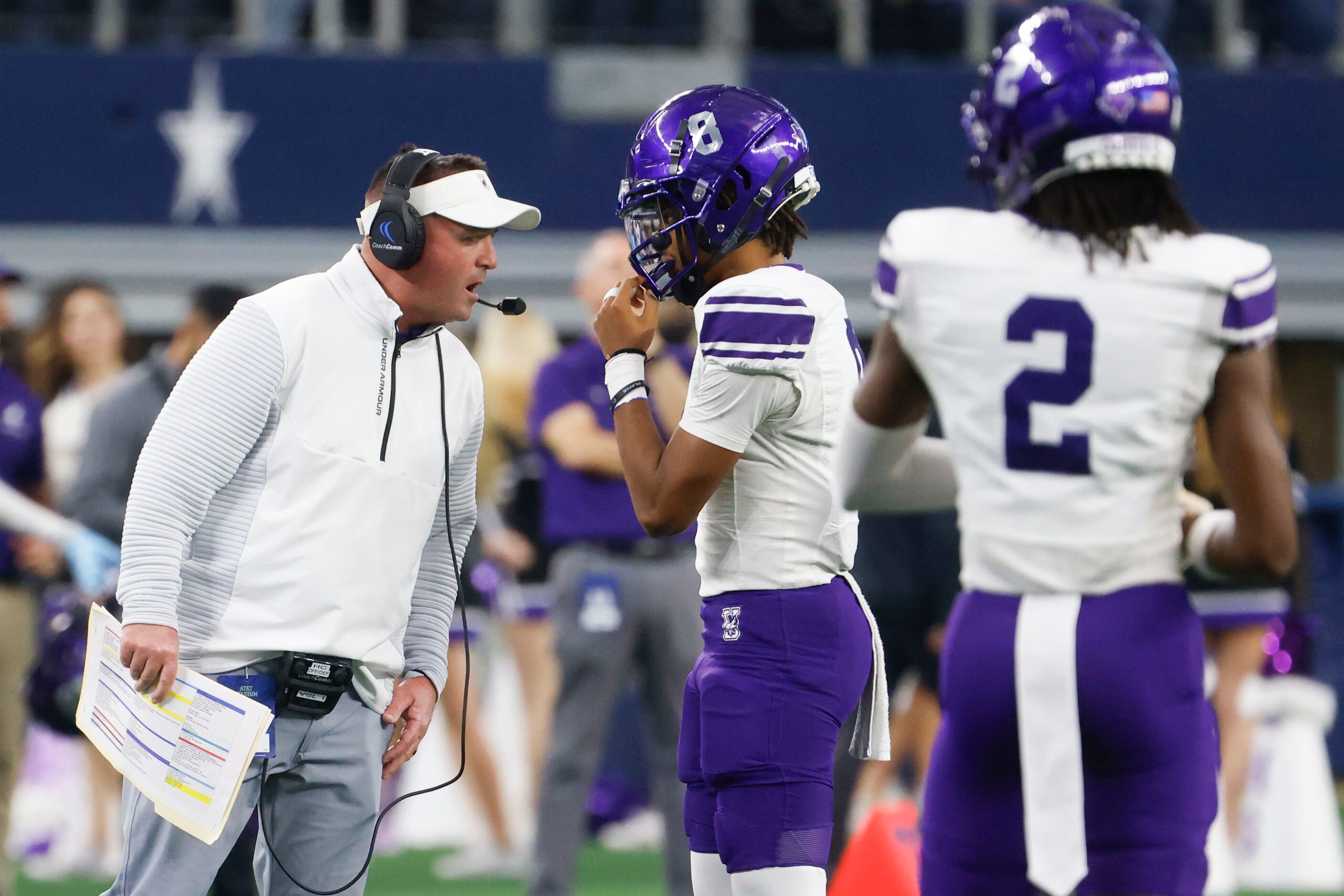 Anna High’s head coach Seth Parr (left) instructs QB Ziondre Williams during the first half...