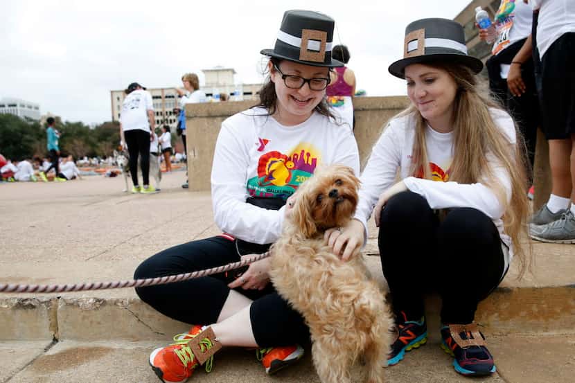 Mara Lipow (left) and Lauren Levine pet a dog named Bella at the 2015 Dallas YMCA Turkey...