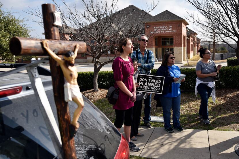 Anti-abortion supporter Anna Marinceo, 20, left, of Flower Mound, Texas, sings religious...