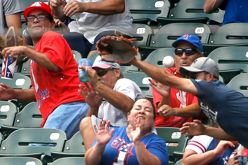ARLINGTON, TX - AUGUST 4: A fan reacts after being stuck in the forehead by a foul ball off...
