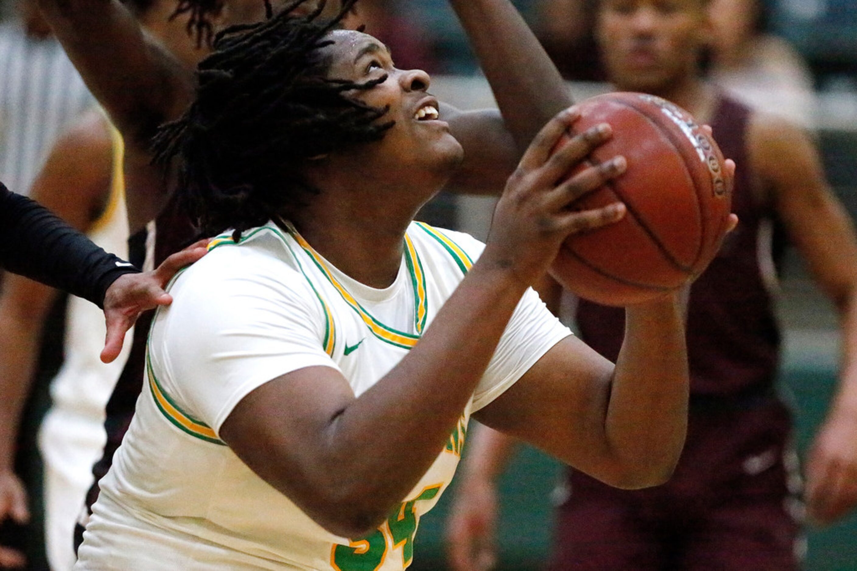 Madison High School Warren Dunn (34) attempts to put up a shot during the first half as...