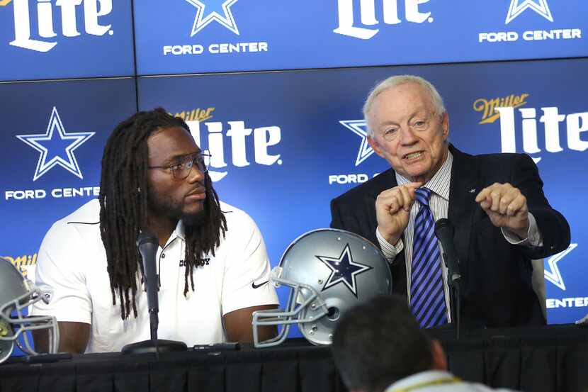 Dallas Cowboys linebacker Jaylon Smith (center) speaks alongside owner Jerry Jones (right)...