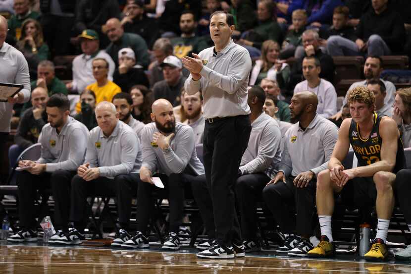 Baylor head coach Scott Drew, center, talks to his team on the floor during the first half...