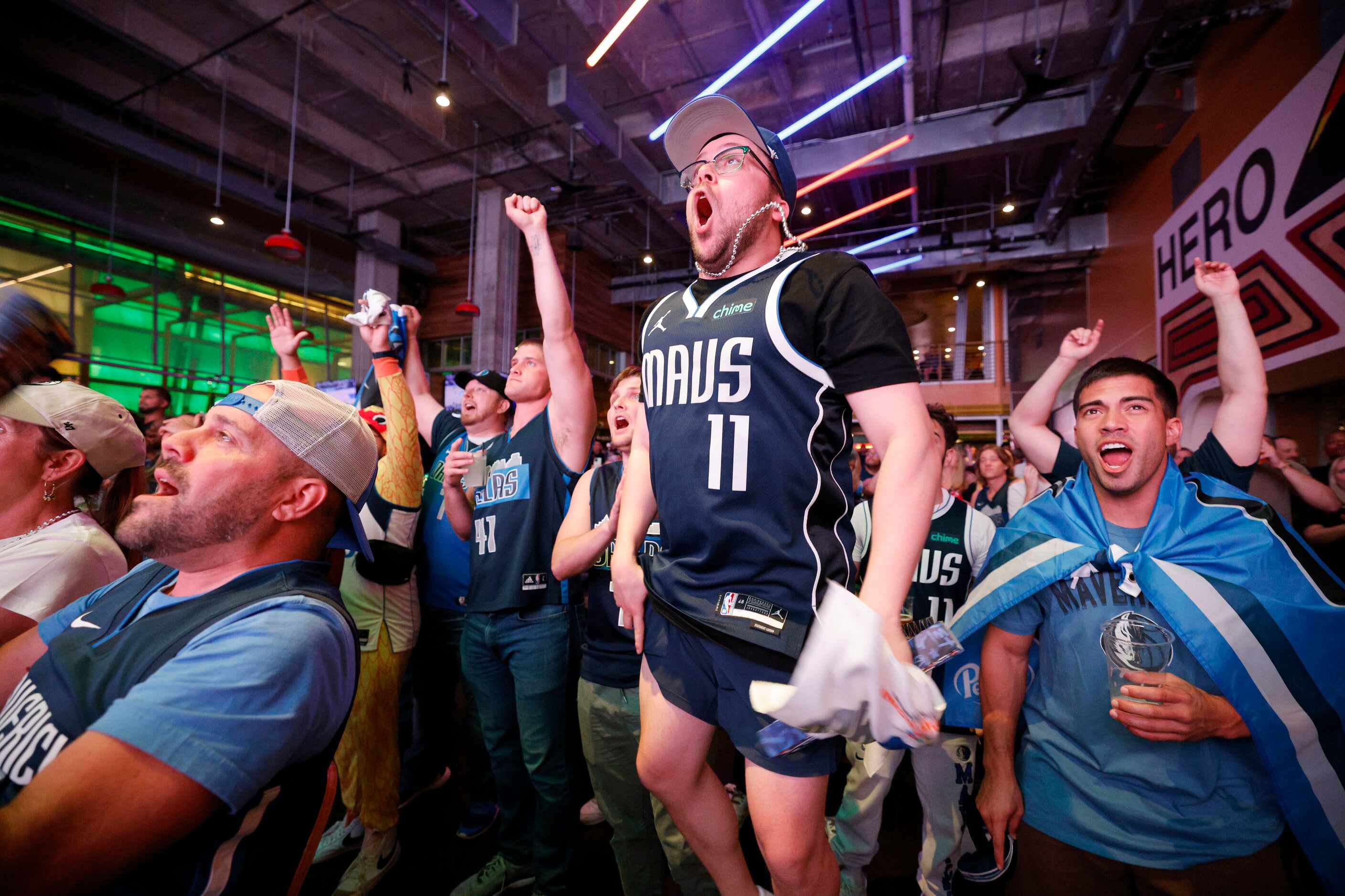 Dallas Mavericks fan Matthew Singer of Dallas, center jumps during a Game 1 watch party of...