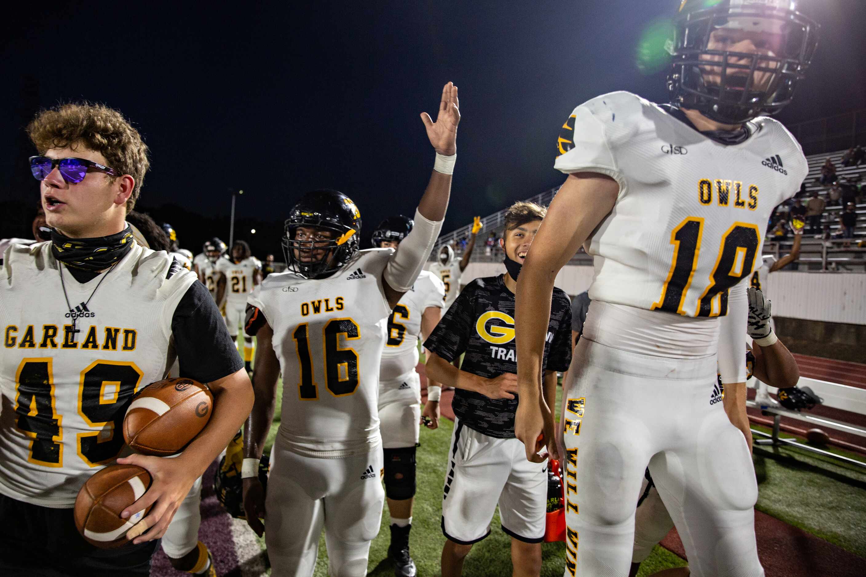 Garland High School players celebrate as defensive back Chace Biddle runs with an...
