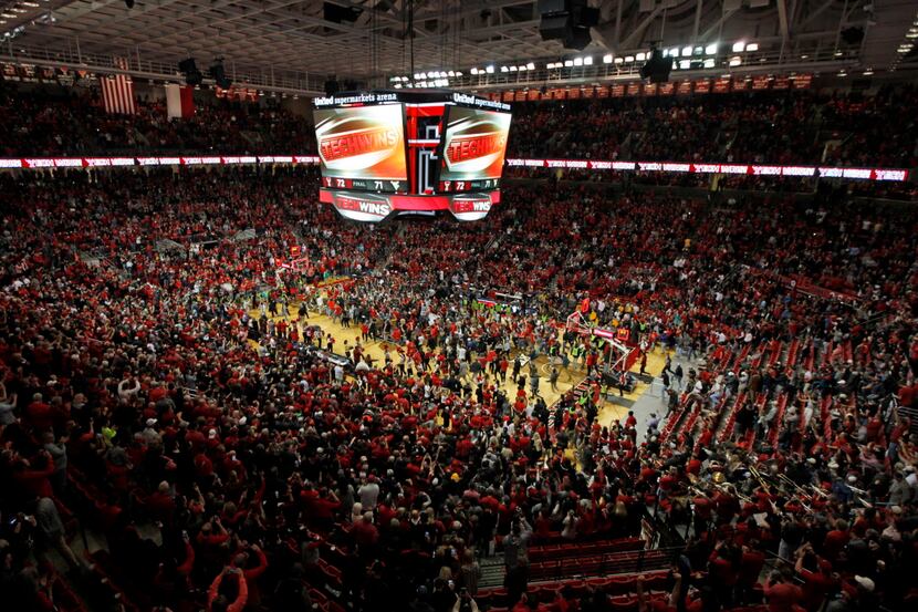 Texas Tech fans celebrate on the court after the second half of an NCAA college basketball...