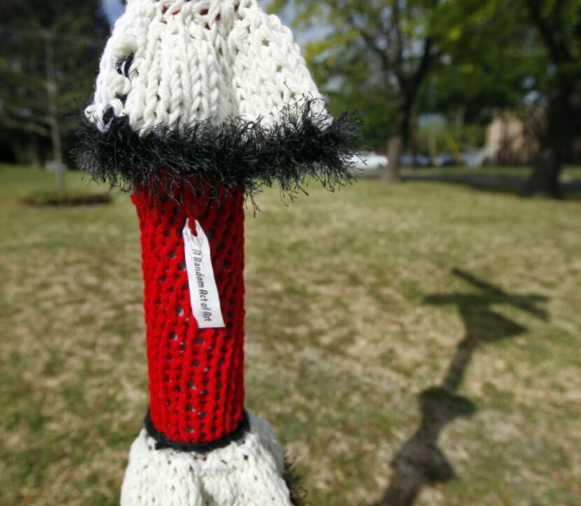 Local yarn bomber K Witta leaves her calling card, a tag that says "A Random Act of Art." ...