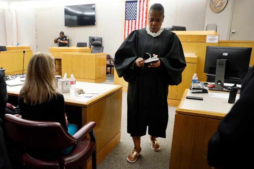 Judge Tammy Kemp opens a Bible to John 3:16 before giving it to Amber Guyger. Kemp gave her...