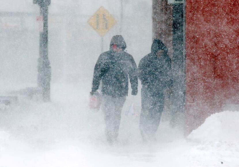 Pedestrians walk in whiteout conditions during a snowstorm, Thursday, Feb. 9, 2017, in...