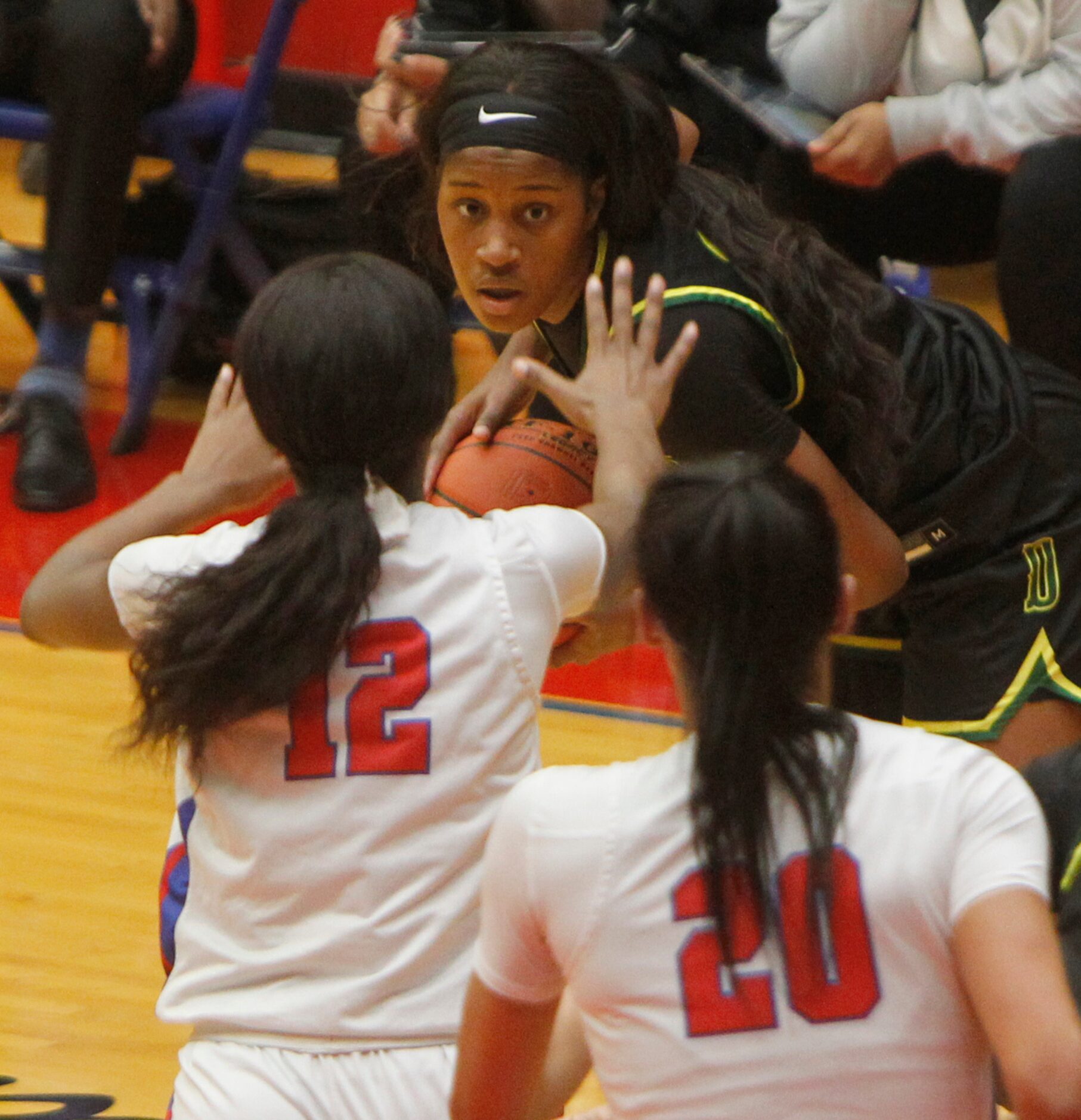 DeSoto's Ayanna Thompson (20), top, eyes the defense of Duncanville's Kaylinn Kemp (12) and...