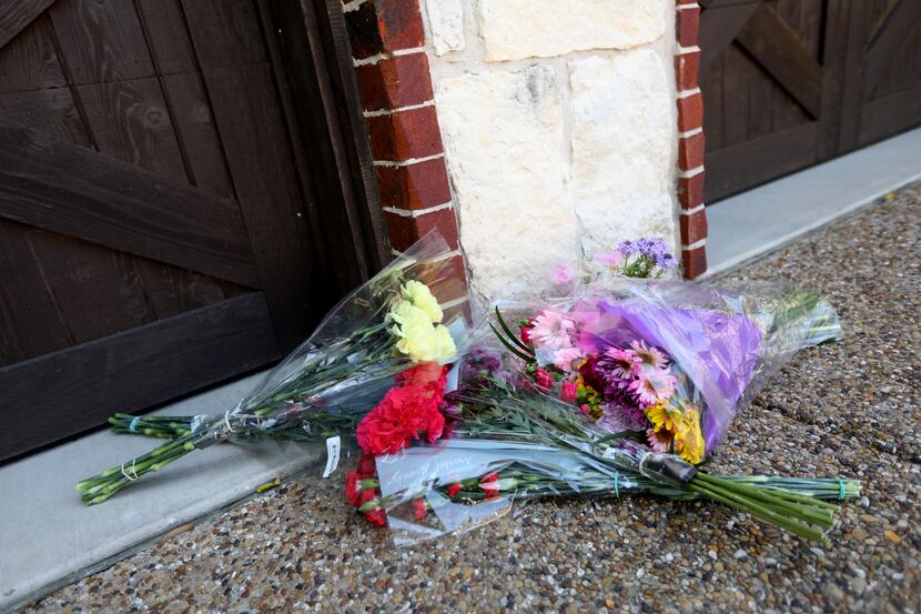 Flowers are left at a home where a 20-year-old man is believed to have killed his...