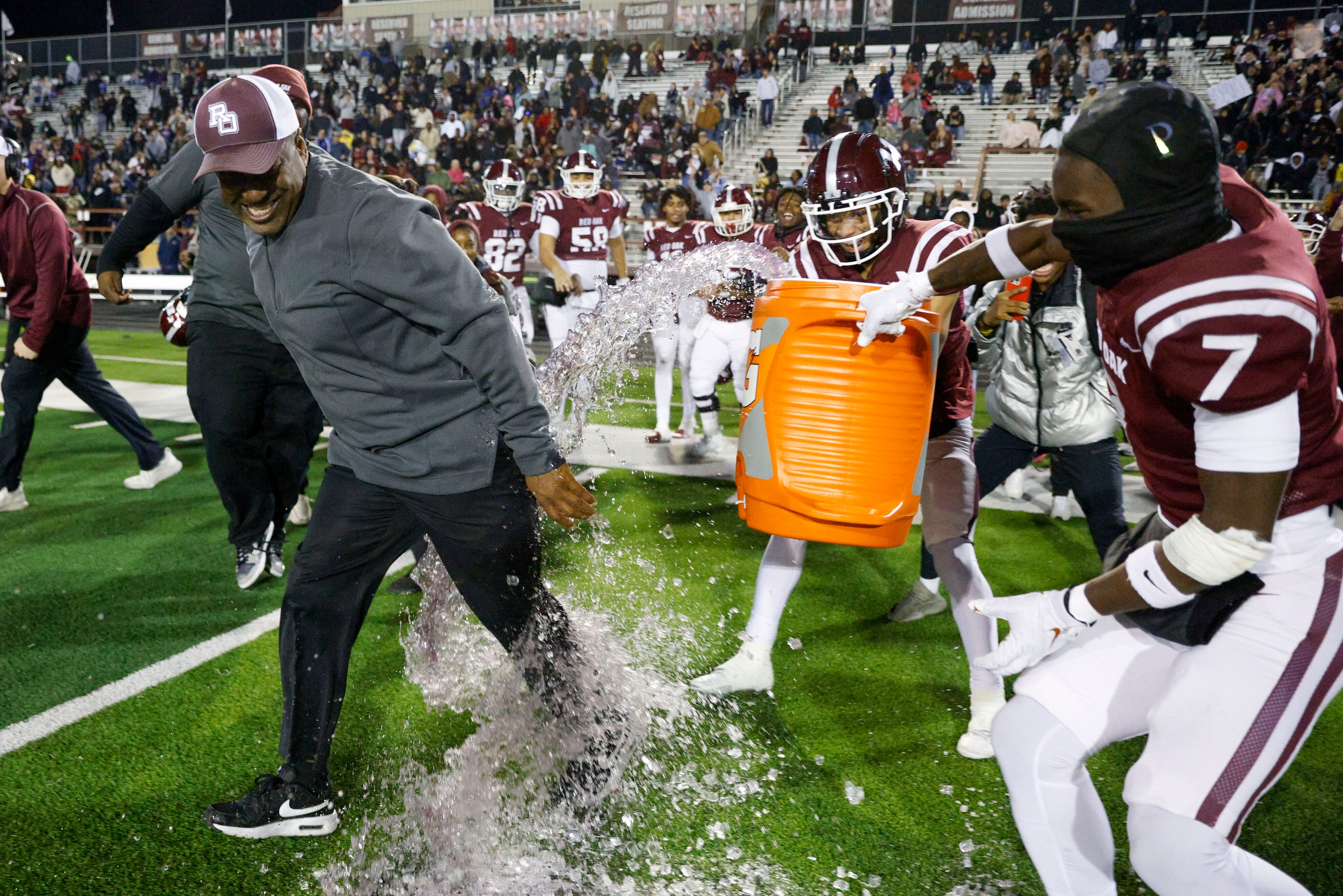 Red Oak head coach Melvin Robinson avoids a Gatorade bath from wide receivers Dylan Gayton...