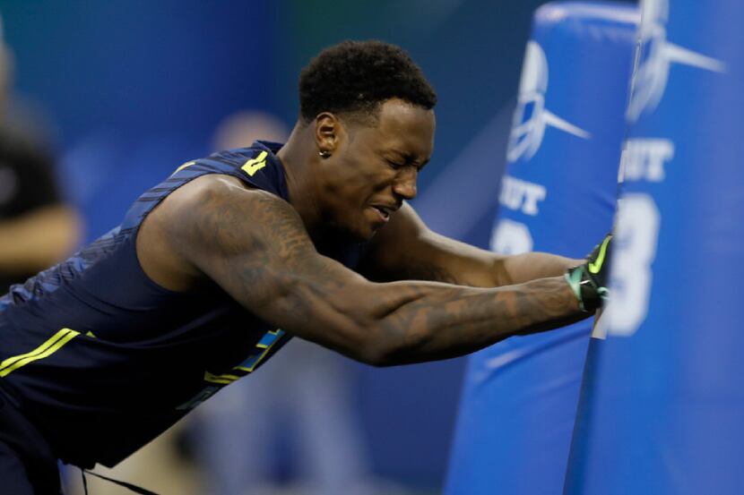 Michigan defensive end Taco Charlton runs a drill at the NFL football scouting combine on...