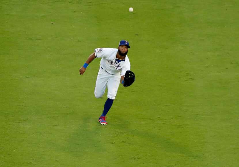 Texas Rangers center fielder Danny Santana reaches out to field a fly out by Tampa Bay Rays'...