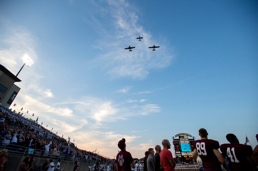 Two T-6 airplanes and an RV-8 airplane perform a flyover before a high school football game...