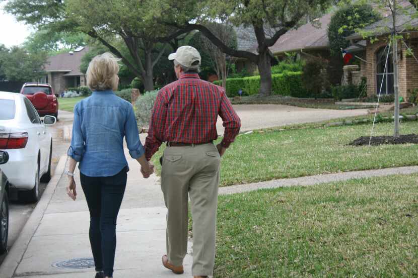 Margaret and Michael Filingeri walk down a sidewalk in their Prestonwood neighborhood. The...