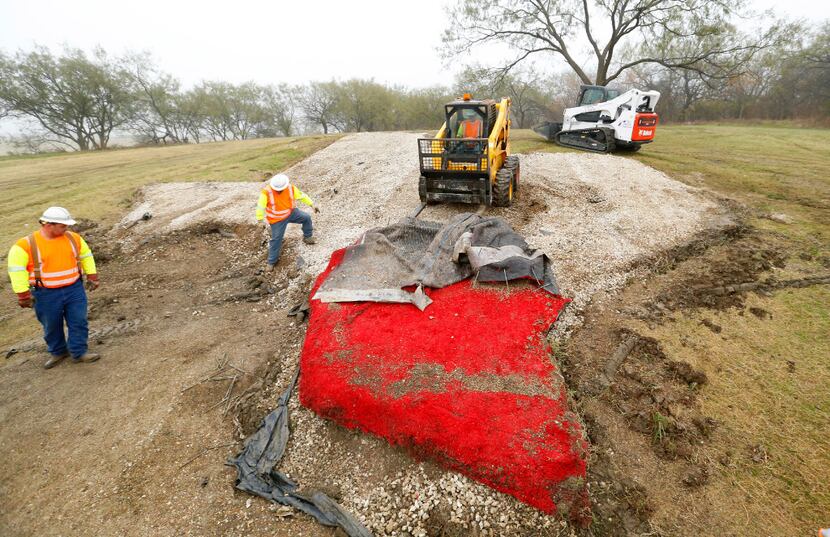 Texas Department of Transportation crews removed the red turf portion of the Texas-shaped...
