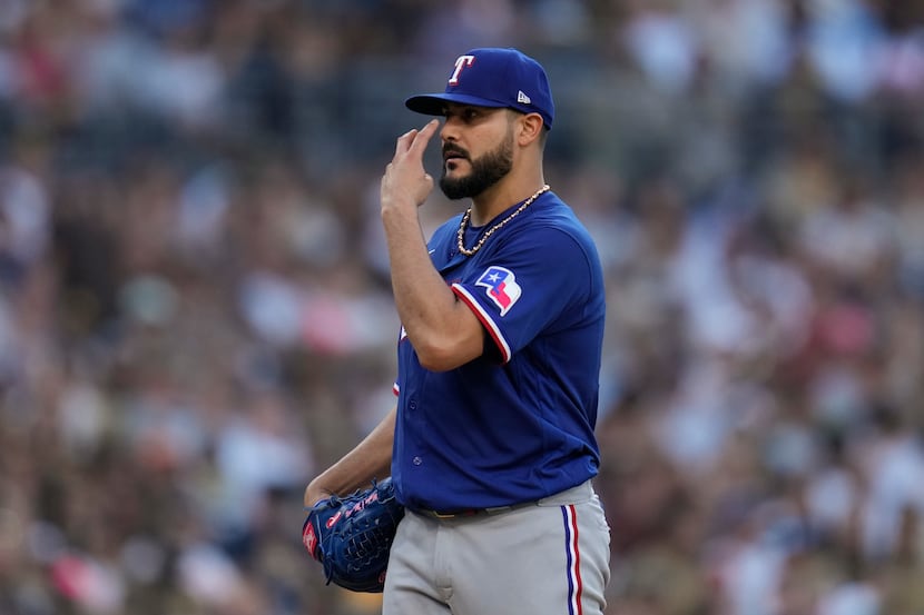 Texas Rangers starting pitcher Martin Perez gestures after being called for a balk during...
