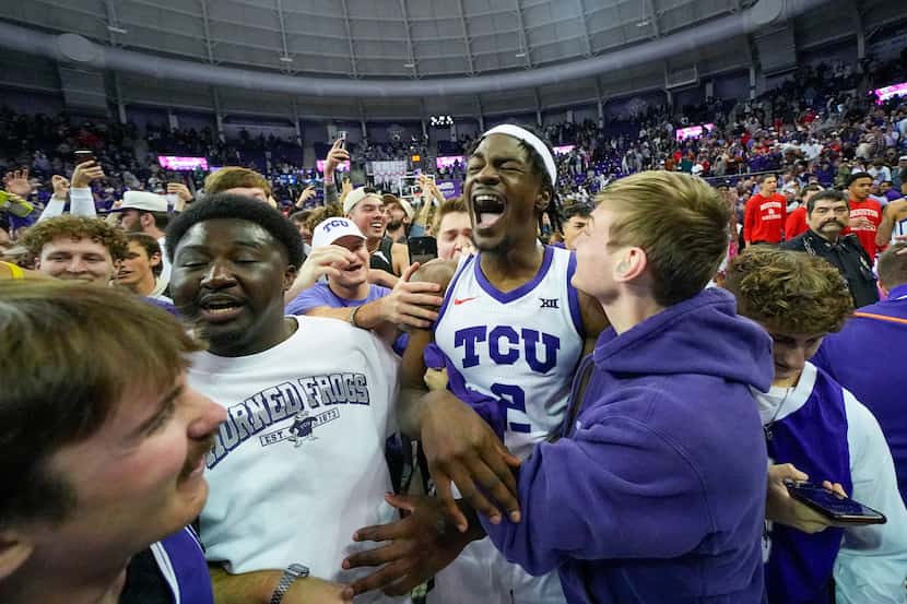 TCU forward Emanuel Miller, center, is approached by a students after TCU defeated No....