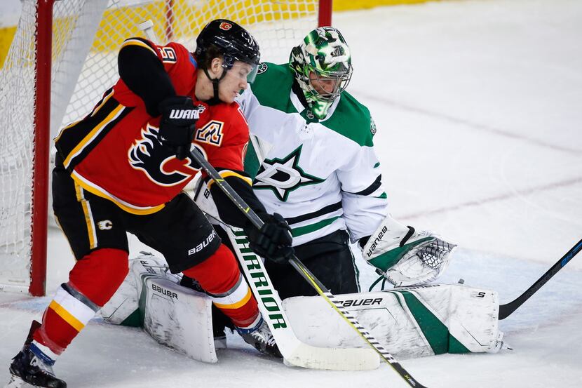Dallas Stars goalie Ben Bishop, right, blocks the net on Calgary Flames' Matthew Tkachuk...