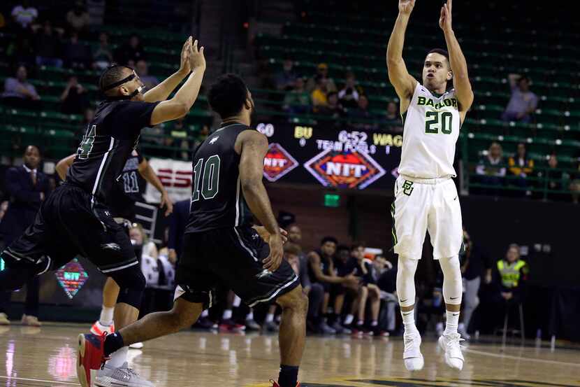 Baylor guard Manu Lecomte, right, shoots over Wagner guard Devin Liggeons, left, and guard...