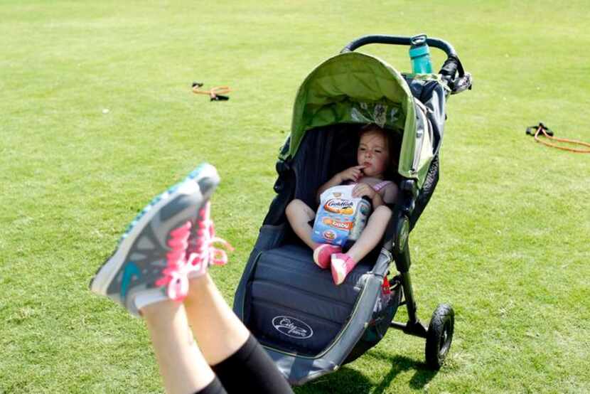 
Hannah Miller, 22 months, enjoys a snack while her mother Stephanie Miller exercises at a...