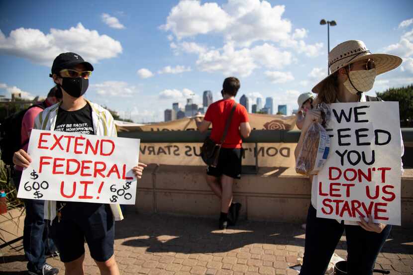 Linh Bui (left) and Ivy Vance (right) hold signs asking for the extension of federal...