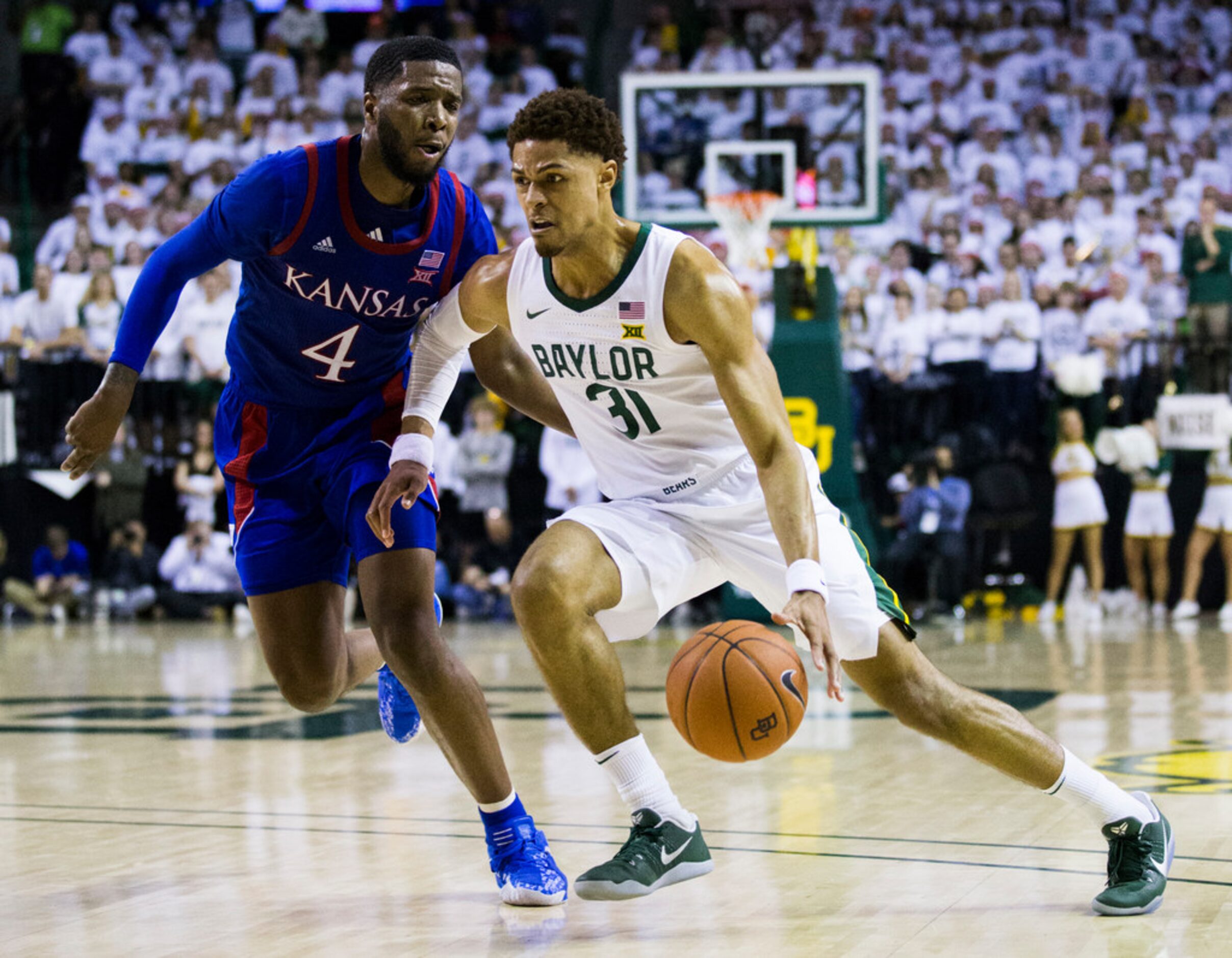 Baylor Bears guard MaCio Teague (31) best past Kansas Jayhawks guard Isaiah Moss (4) during...