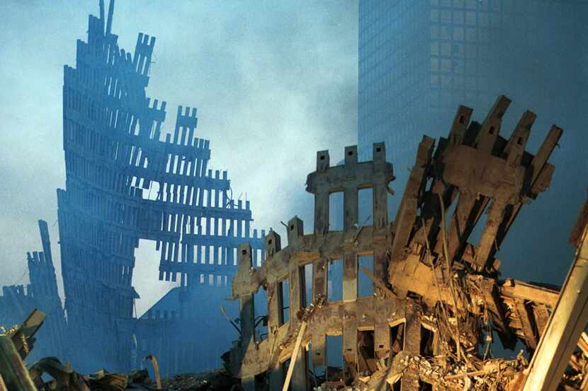 Early-morning light hit the smoke and wreckage of the World Trade Center on Sept. 13, 2001,...