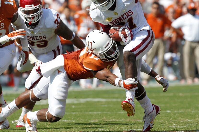 Texas Longhorns safety Adrian Phillips (17) tacklels Oklahoma Sooners running back Keith...