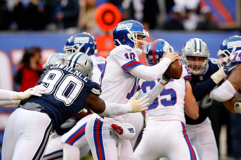 Cowboys defensive end DeMarcus Lawrence (90) pressures New York Giants quarterback Eli...