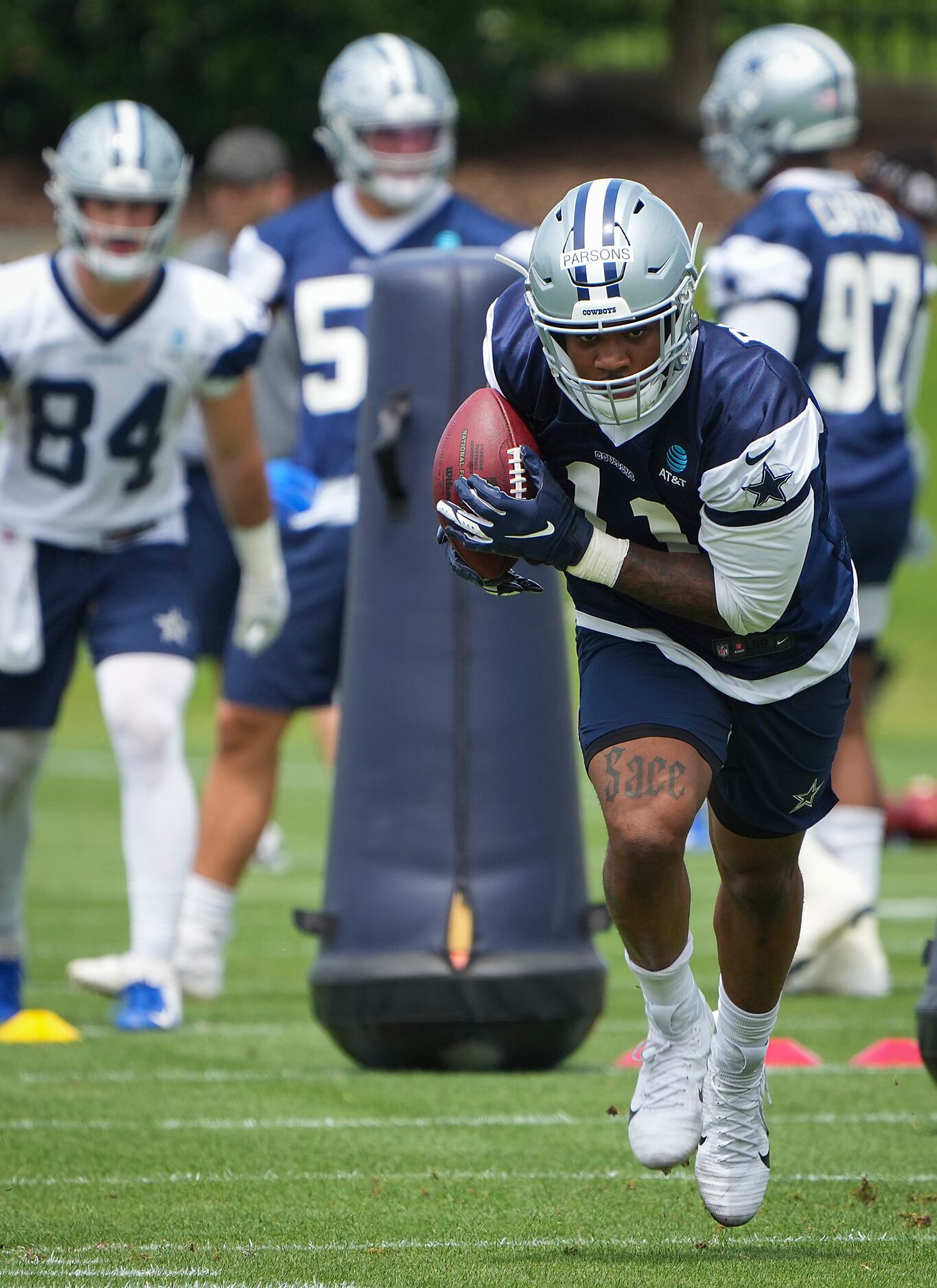 Dallas Cowboys linebacker Micah Parsons (11) scoops up a ball in drill during a minicamp...