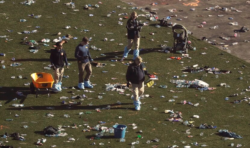 Investigators walk through debris on festival grounds across the street from the Mandalay...