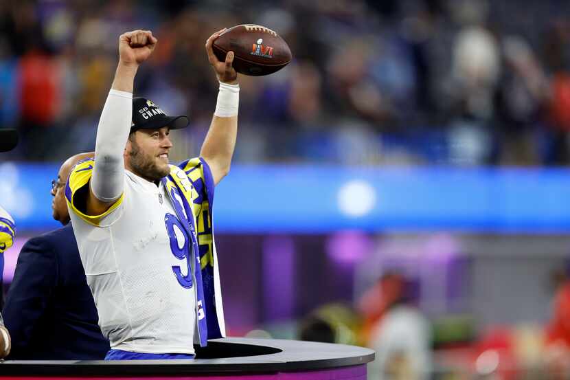 Los Angeles Rams quarterback Matthew Stafford (9) celebrates, holding the ball in the air...