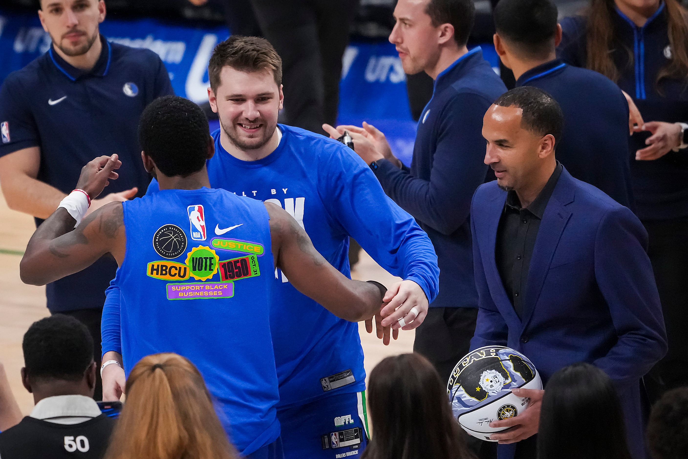 Dallas Mavericks guard Luka Doncic (facing) hugs guard Kyrie Irving after bing recognized...