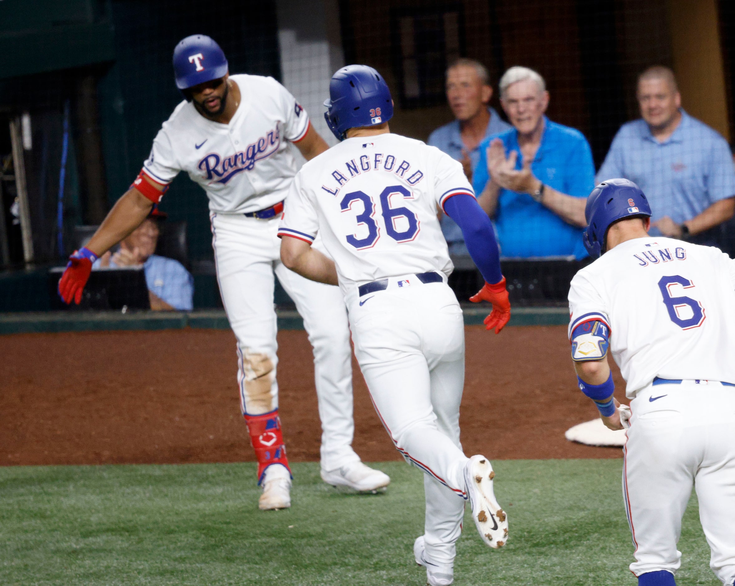 Texas Rangers outfielder Leody Taveras (3) gives high-fives to Texas Rangers outfielder...