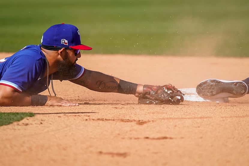 The Rangers’ Rougned Odor can’t make a diving tag in time as Seattle’s Jordan Cowan steals...