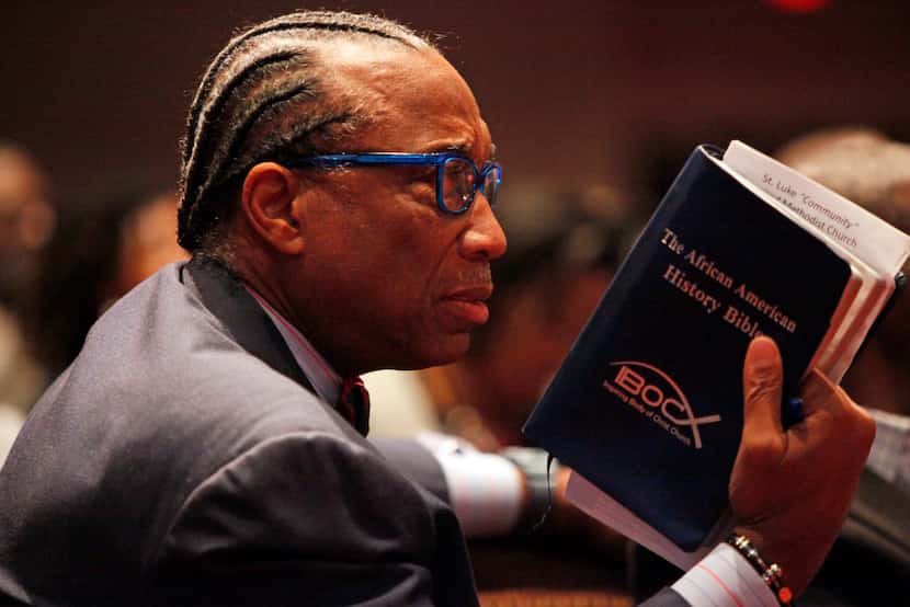 Price held up his Bible as he listened to author and professor Michael Eric Dyson speak at a...