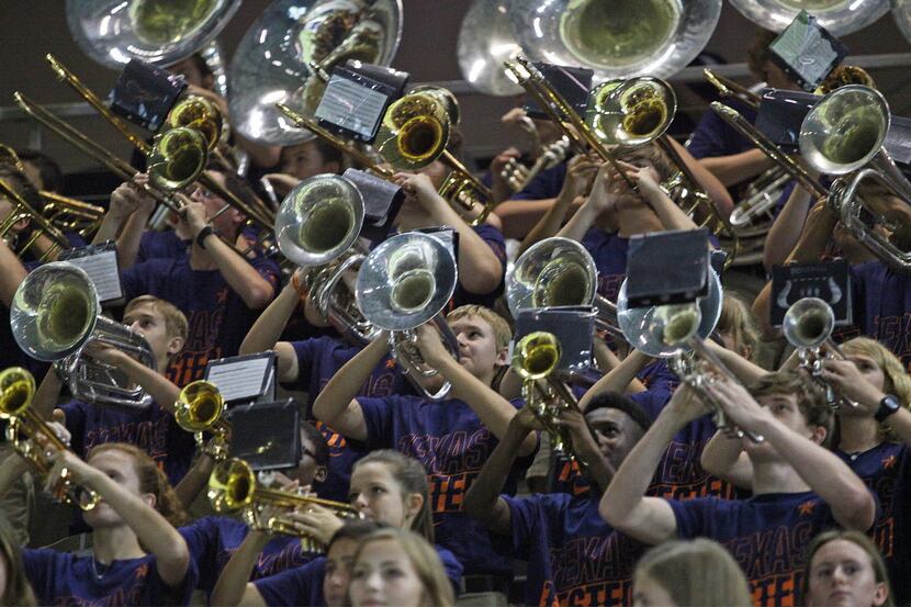 The horn section of the Wakeland High School marching band performs during a varsity...