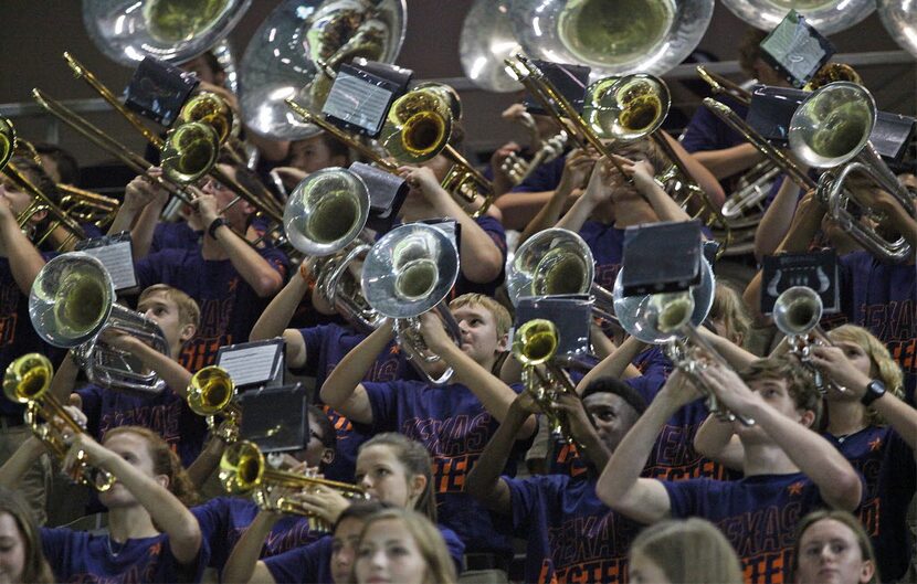 The horn section of the Wakeland High School marching band performs during a varsity...