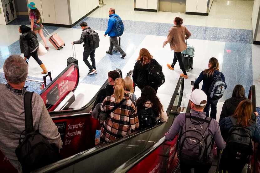 Passengers come off the escalators for the Skylink train at Terminal B at DFW Airport on...