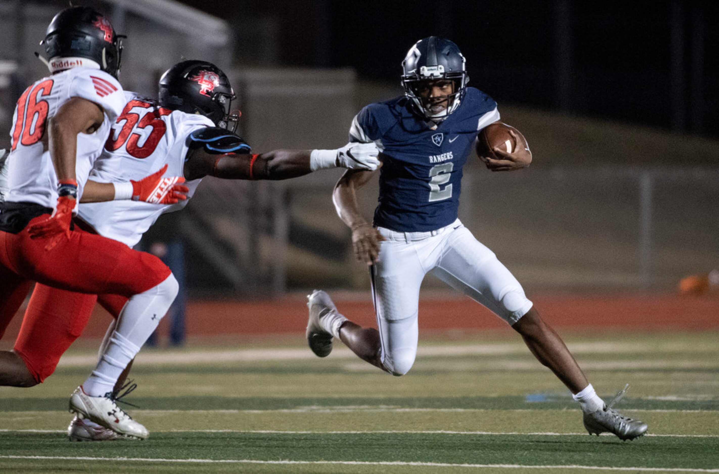 Frisco Lone Star junior quarterback Julian Larry (2) tries to avoid the tackle of Mansfield...