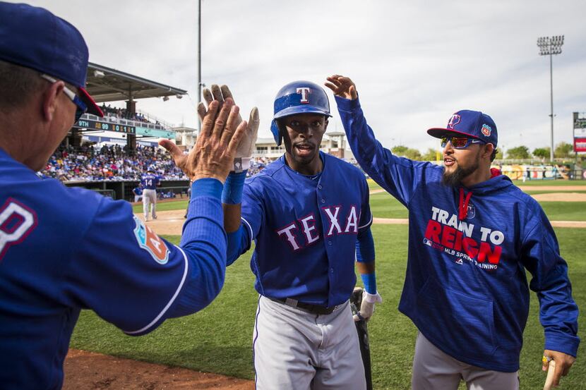 Texas Rangers outfielder James Jones (center) celebrates with manager Jeff Banister and...